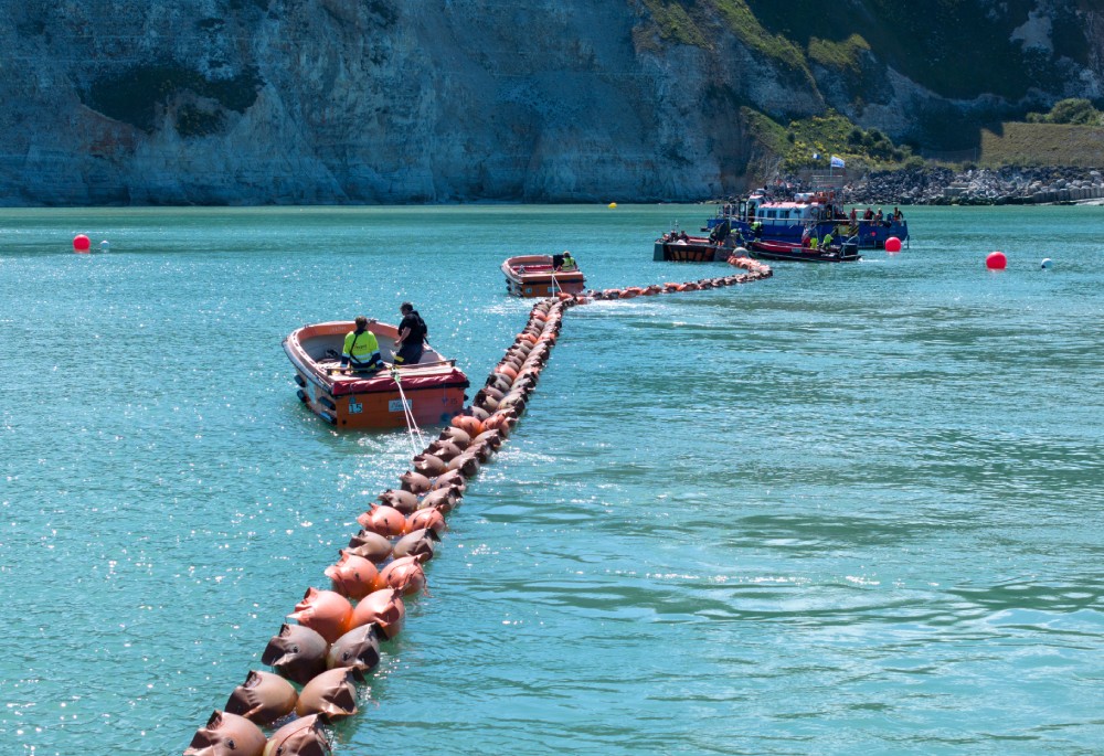 Two small boats navigating a clear blue waterway with mooring buoys.