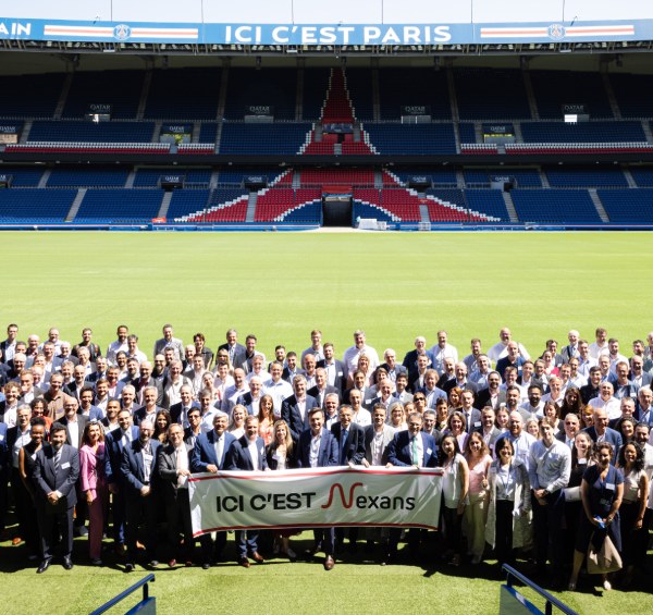 Large group of professionals gathered at a stadium with banner and decorative field design.
