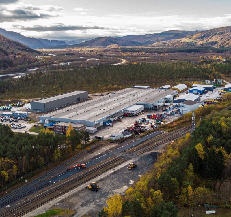 Aerial view of a large industrial facility surrounded by mountains and trees